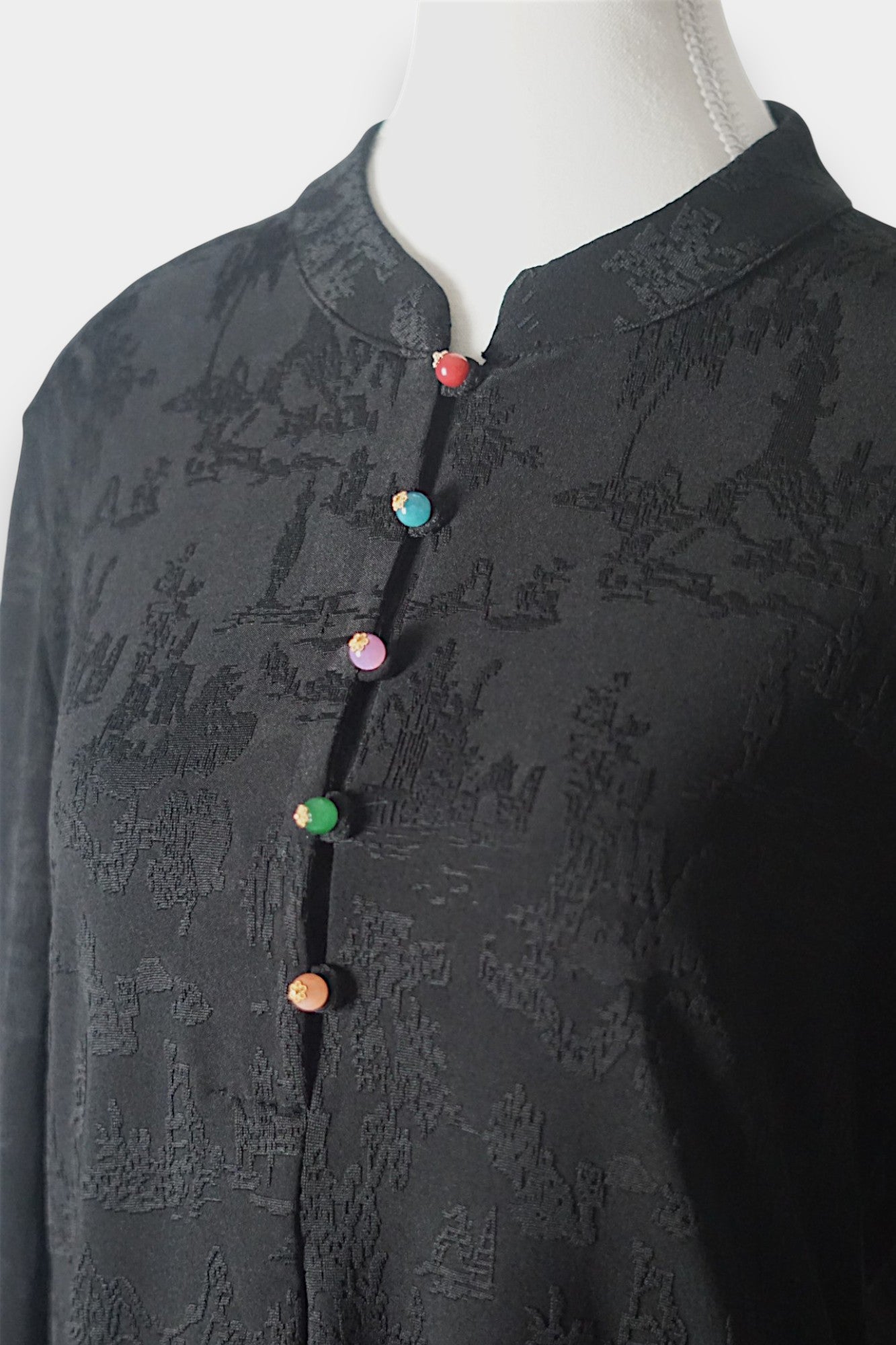 Long sleeve black mandarin collar blouse made from silk spandex blend with embroidery details.