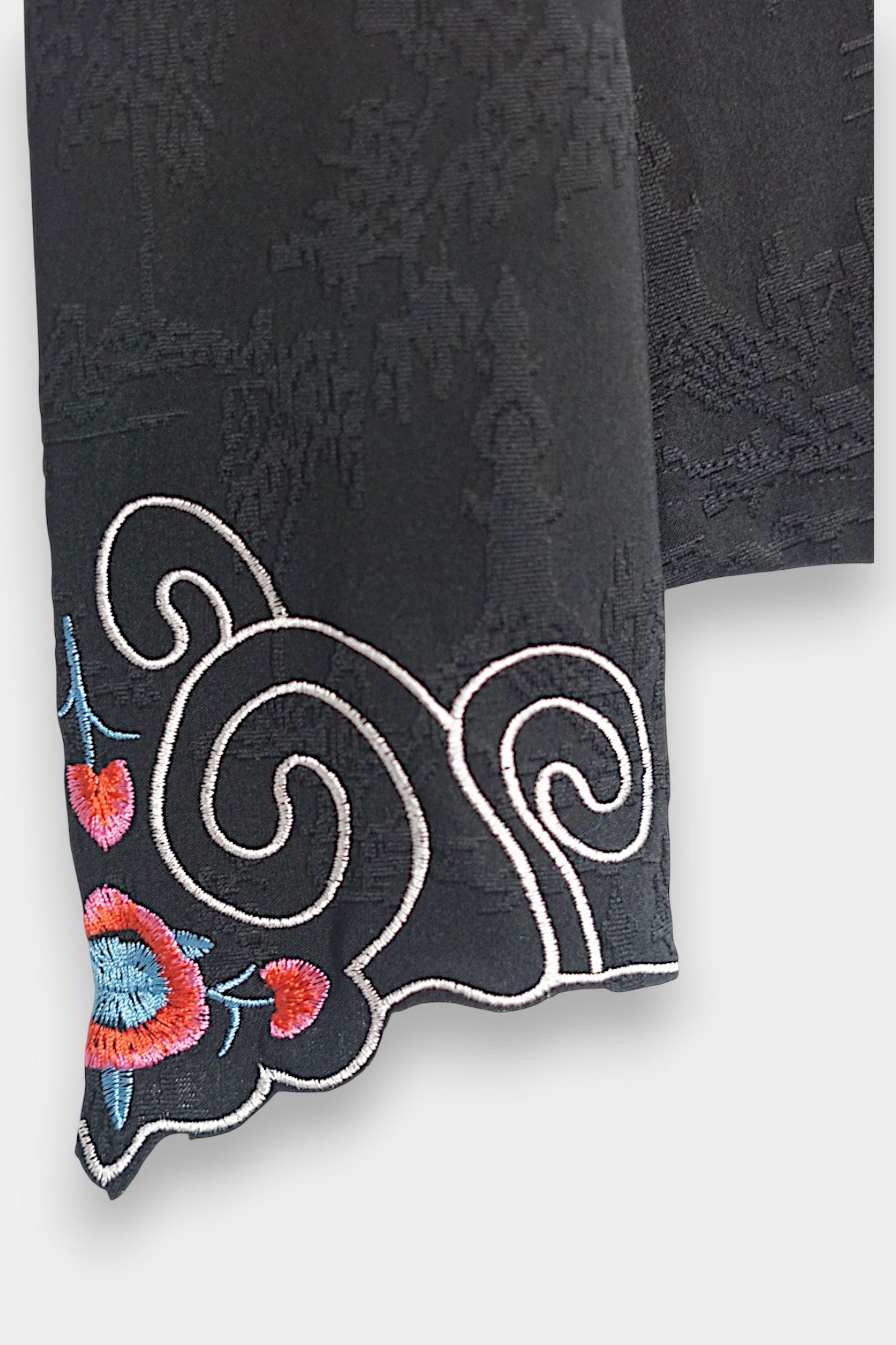 Long sleeve black mandarin collar blouse made from silk spandex blend with embroidery details.