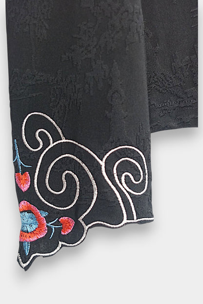 Long sleeve black mandarin collar blouse made from silk spandex blend with embroidery details.