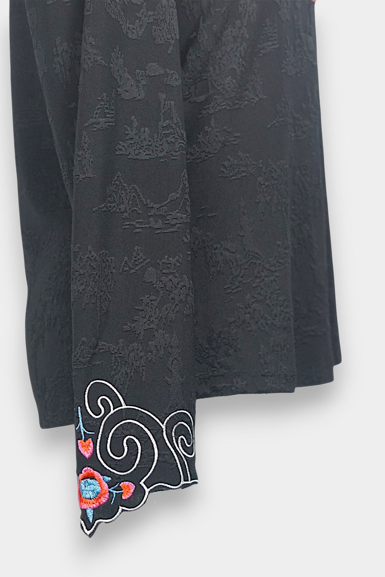 Long sleeve black mandarin collar blouse made from silk spandex blend with embroidery details.