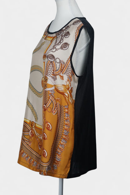 Women's sleeveless beige silk top with gold chain and tassel scarf print and black trim.