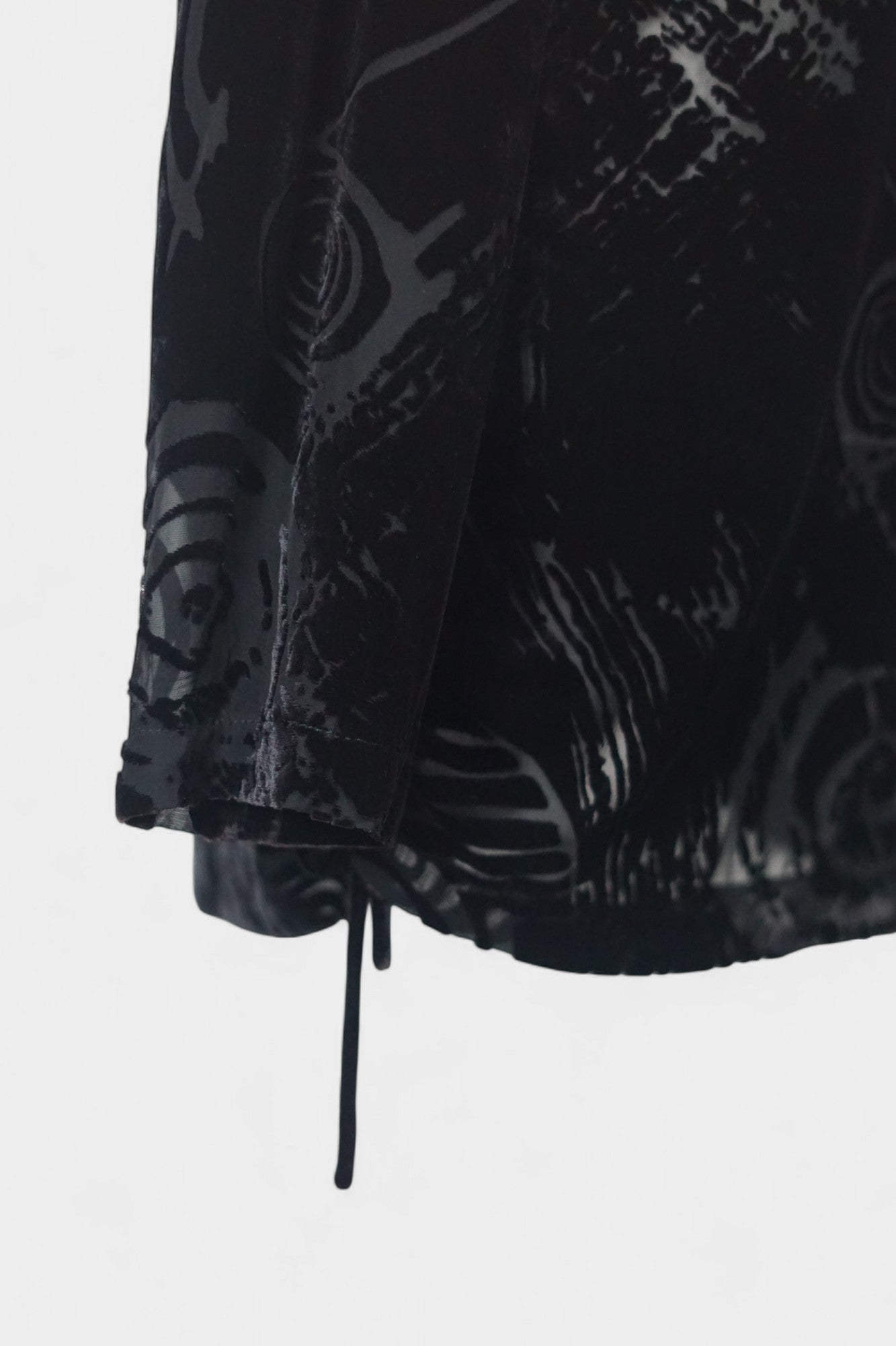 Women's black silk Henley top with grey abstract sketch patterns, buttons, and drawstring hem on a mannequin.
