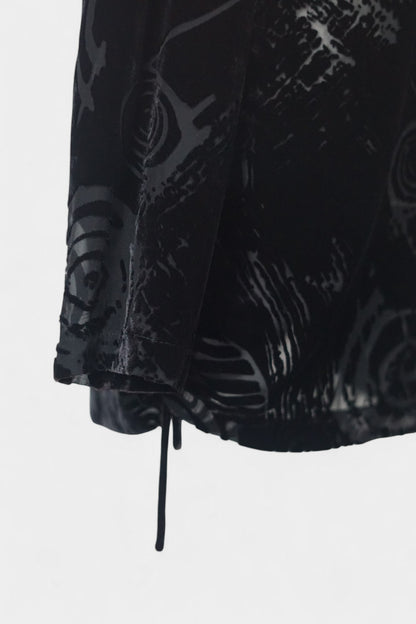Women's black silk Henley top with grey abstract sketch patterns, buttons, and drawstring hem on a mannequin.