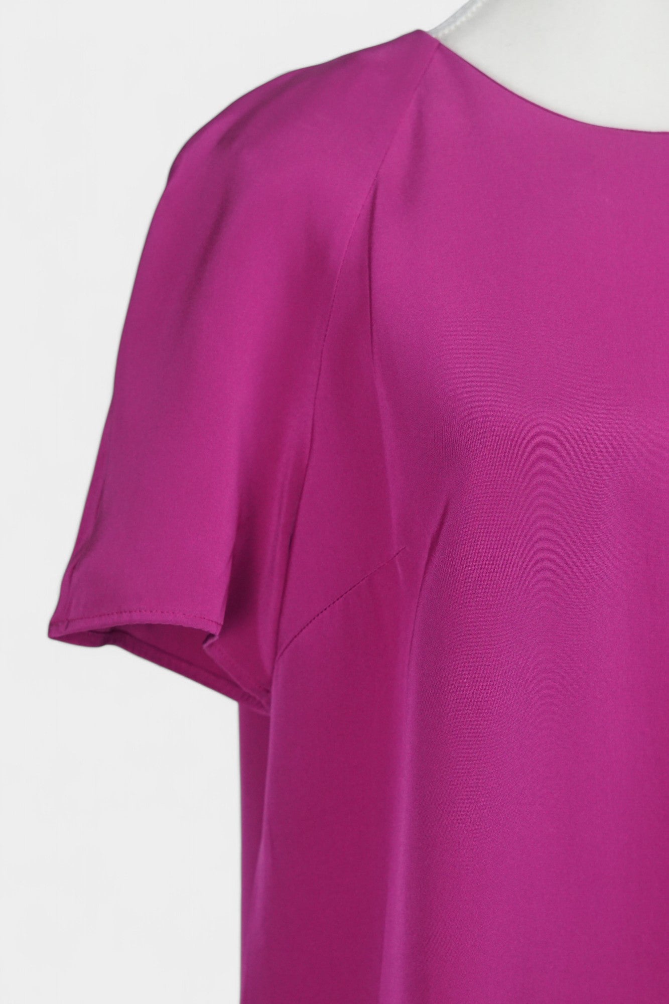 Women's short-sleeve magenta silk top with a round neck and raglan sleeves on a mannequin.
