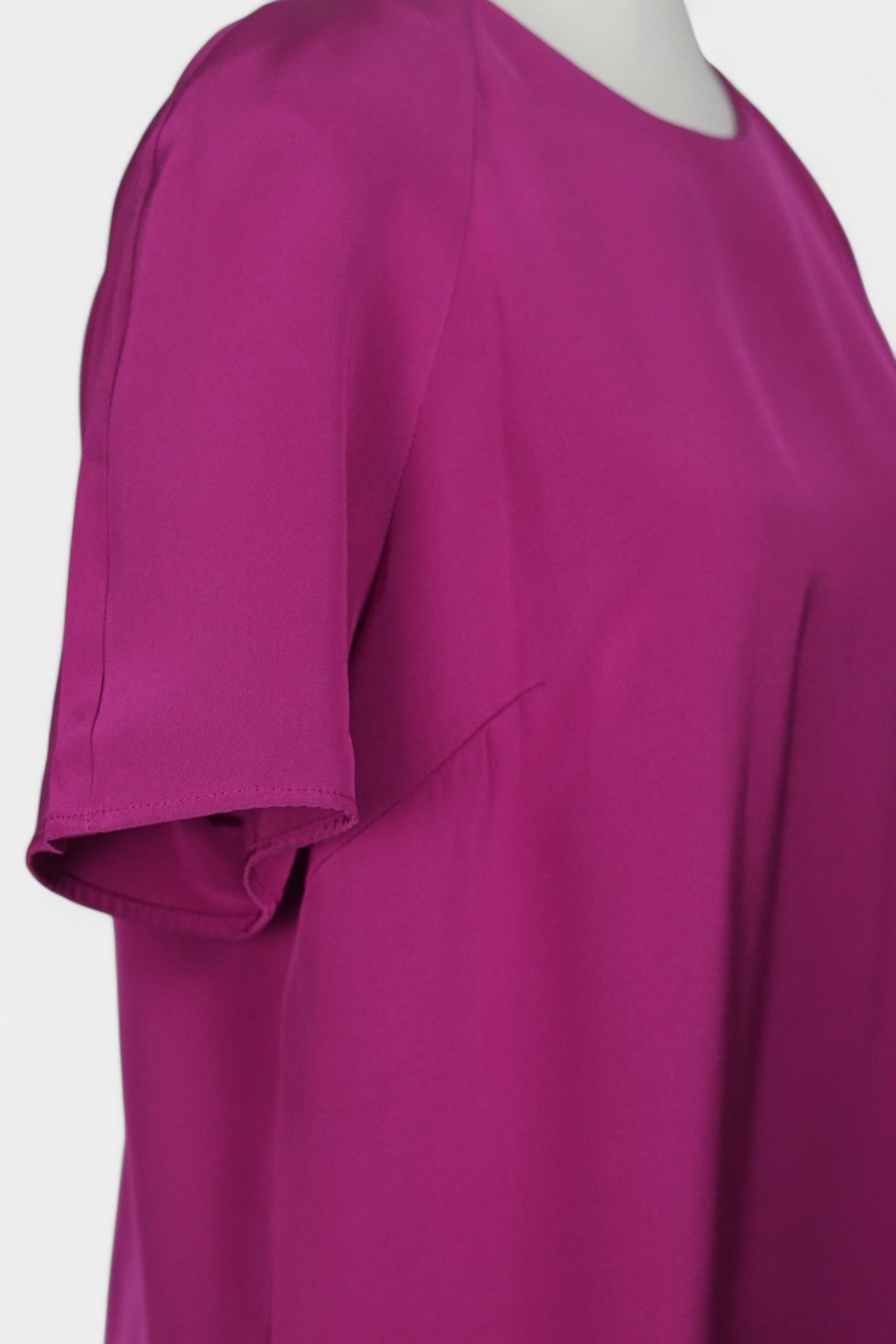 Women's short-sleeve magenta silk top with a round neck and raglan sleeves on a mannequin.
