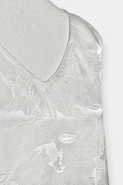 Women's white silk V-neck top with subtle woven koi fish and lotus flower jacquard patterns.