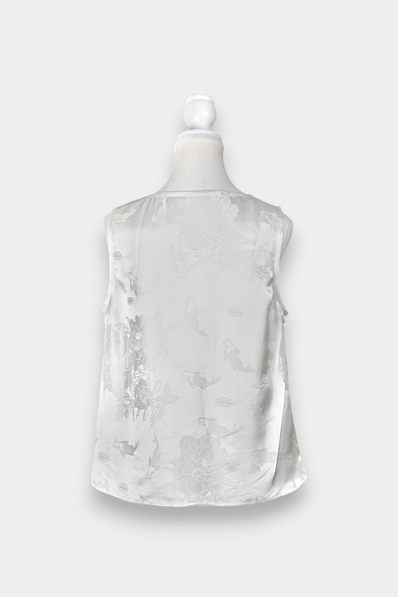 Women's white silk V-neck top with subtle woven koi fish and lotus flower jacquard patterns.