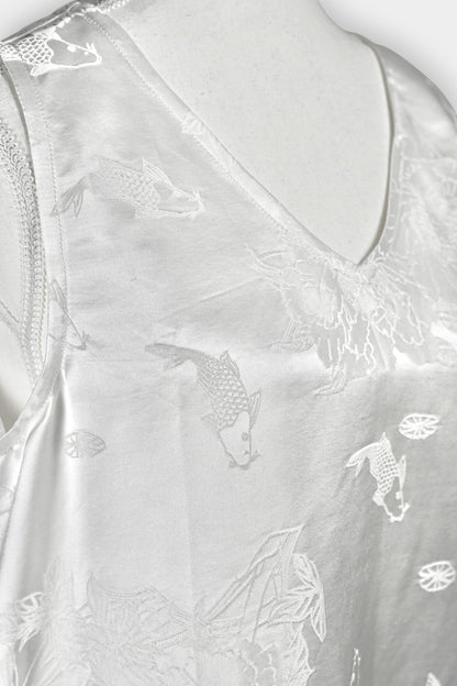 Women's white silk V-neck top with subtle woven koi fish and lotus flower jacquard patterns.