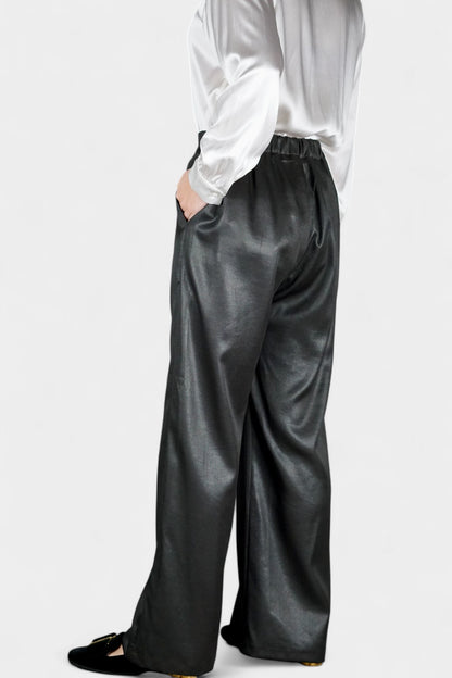 Black wide-leg silk trousers with side pockets and a luxurious satin finish.