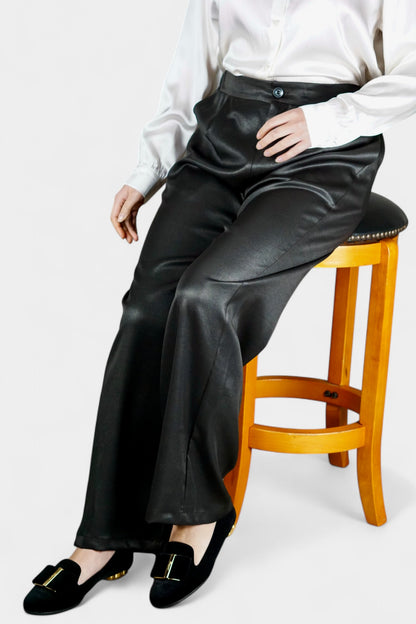 Black wide-leg silk trousers with side pockets and a luxurious satin finish.