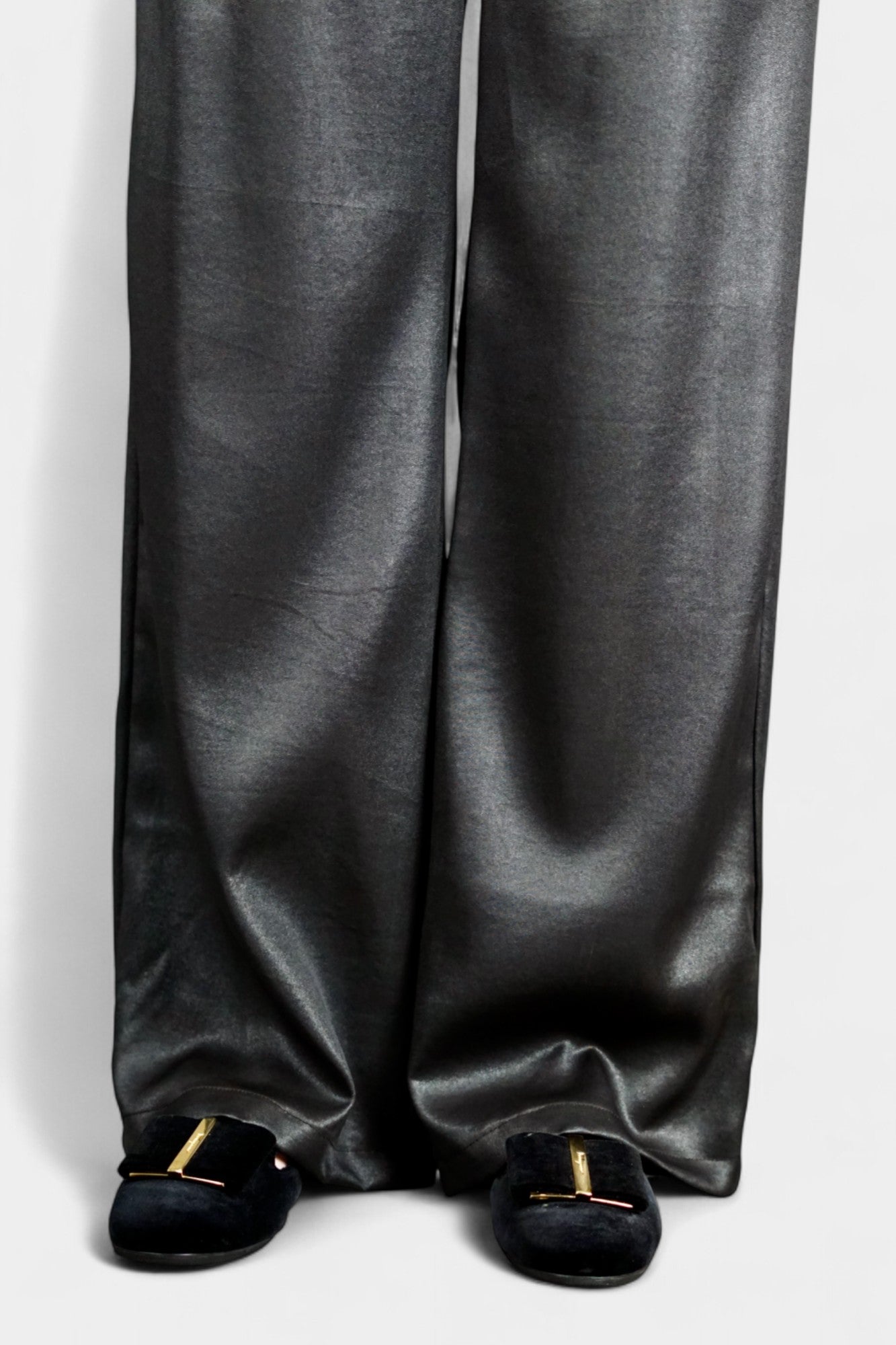 Black wide-leg silk trousers with side pockets and a luxurious satin finish.