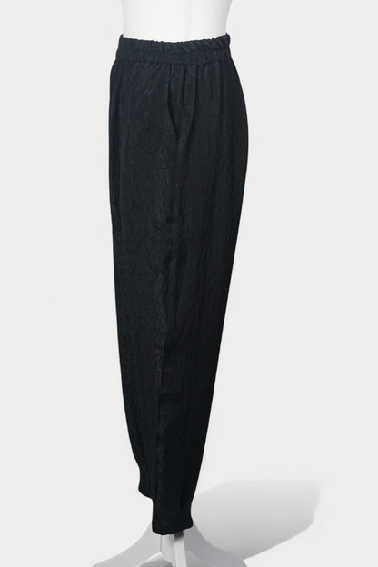 Black textured silk lantern pants with high elastic waistband and tapered ankles