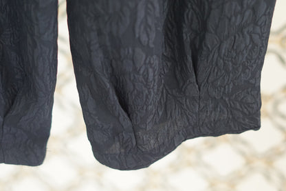 Black textured silk lantern pants with high elastic waistband and tapered ankles