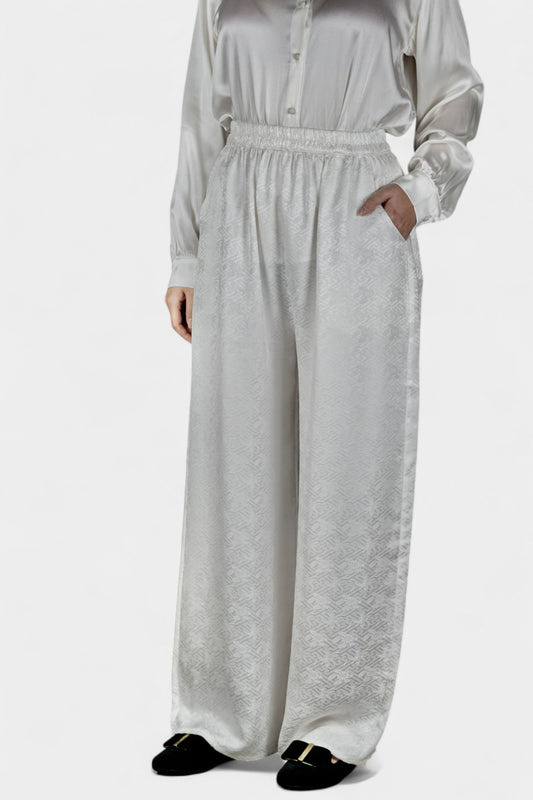 Pearl white wide-leg silk trousers featuring a subtle geometric jacquard pattern and elastic waistband