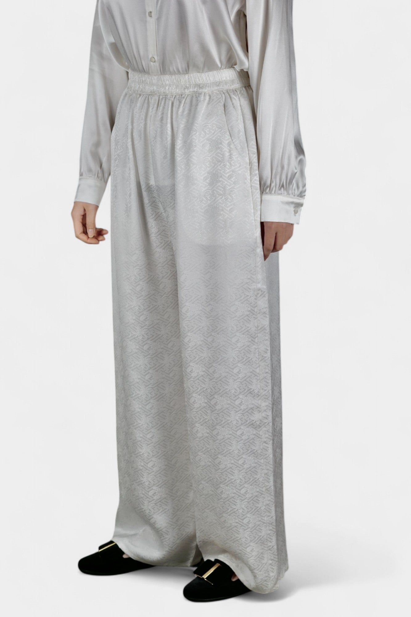 Pearl white wide-leg silk trousers featuring a subtle geometric jacquard pattern and elastic waistband