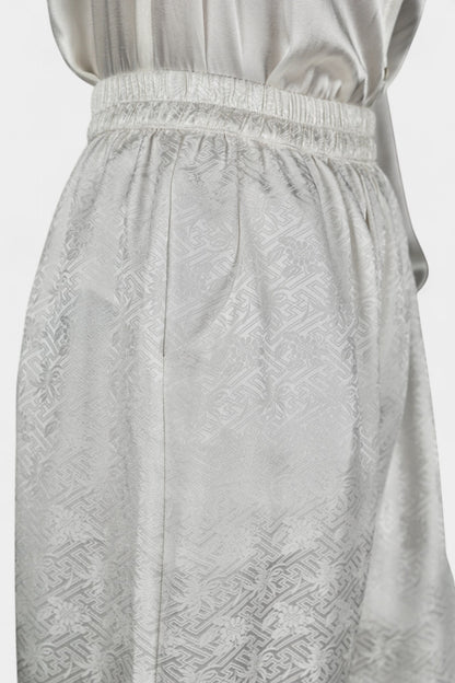 Pearl white wide-leg silk trousers featuring a subtle geometric jacquard pattern and elastic waistband