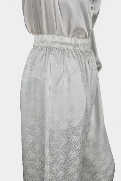 Pearl white wide-leg silk trousers featuring a subtle geometric jacquard pattern and elastic waistband