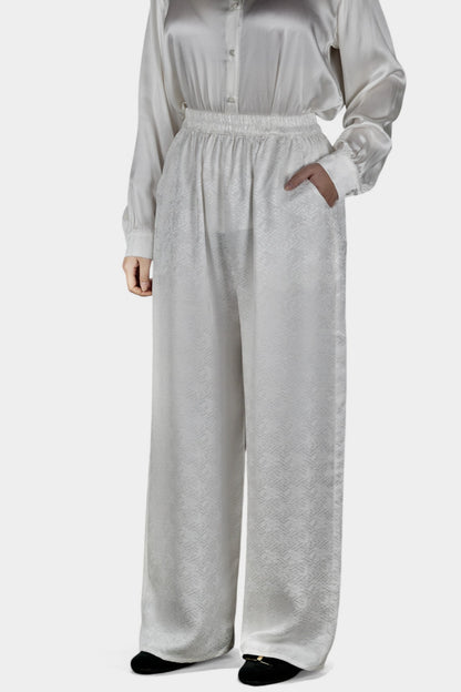Pearl white wide-leg silk trousers featuring a subtle geometric jacquard pattern and elastic waistband