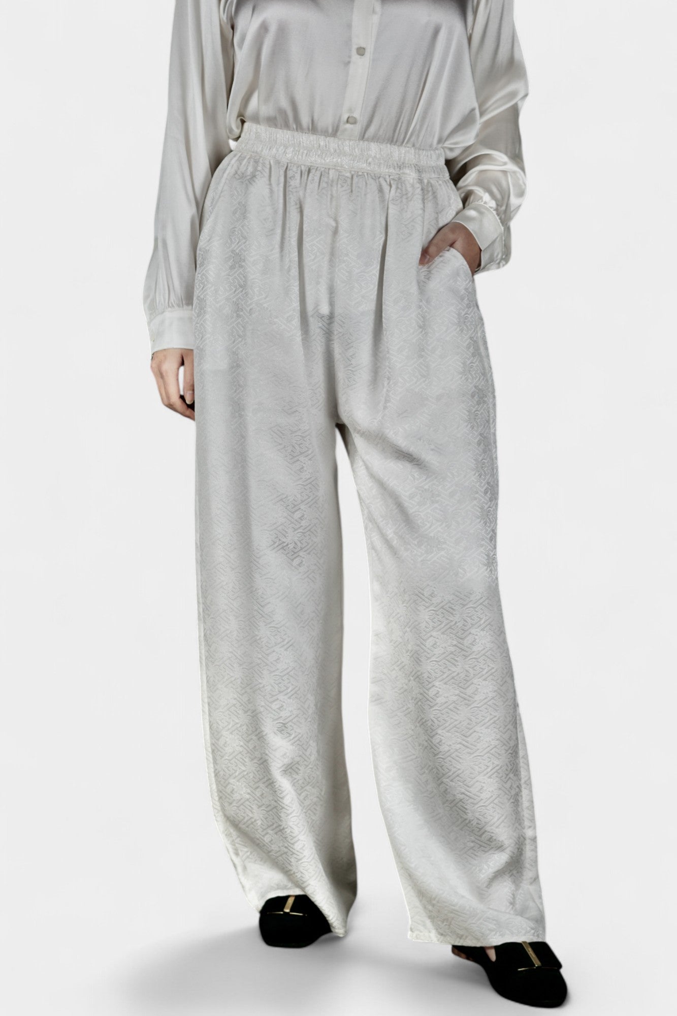 Pearl white wide-leg silk trousers featuring a subtle geometric jacquard pattern and elastic waistband