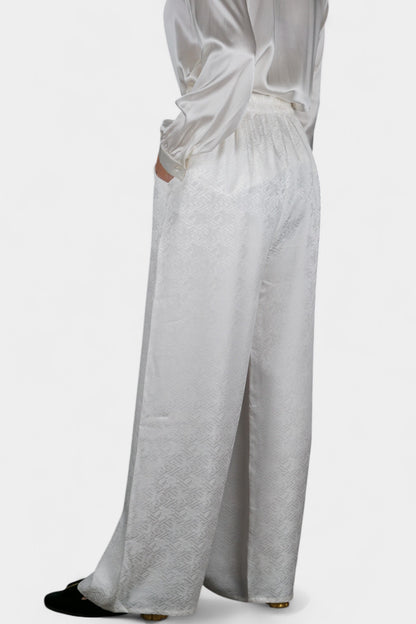 Pearl white wide-leg silk trousers featuring a subtle geometric jacquard pattern and elastic waistband