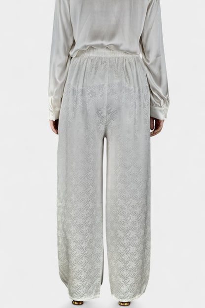 Pearl white wide-leg silk trousers featuring a subtle geometric jacquard pattern and elastic waistband