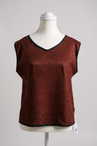 Rust red side of a reversible Gambiered Guangdong Gauze silk vest with black piping trim and traditional cloud pattern