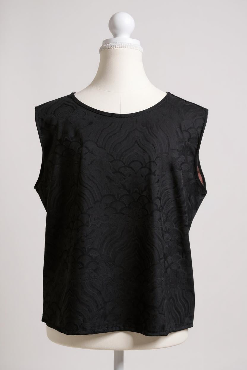 Black side of a reversible women's silk vest featuring a textured wave jacquard pattern and V-neckline
