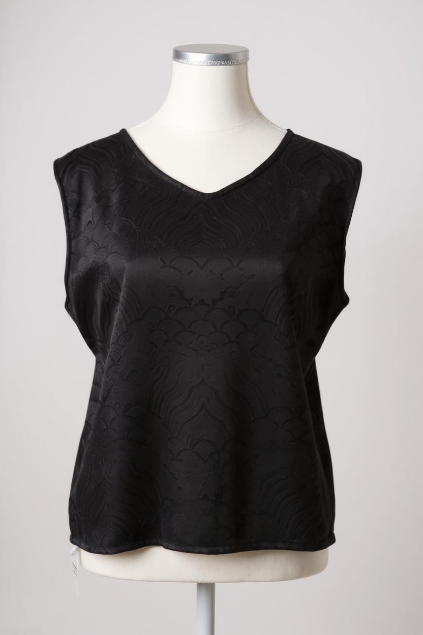 Black side of a reversible women's silk vest featuring a textured wave jacquard pattern and V-neckline