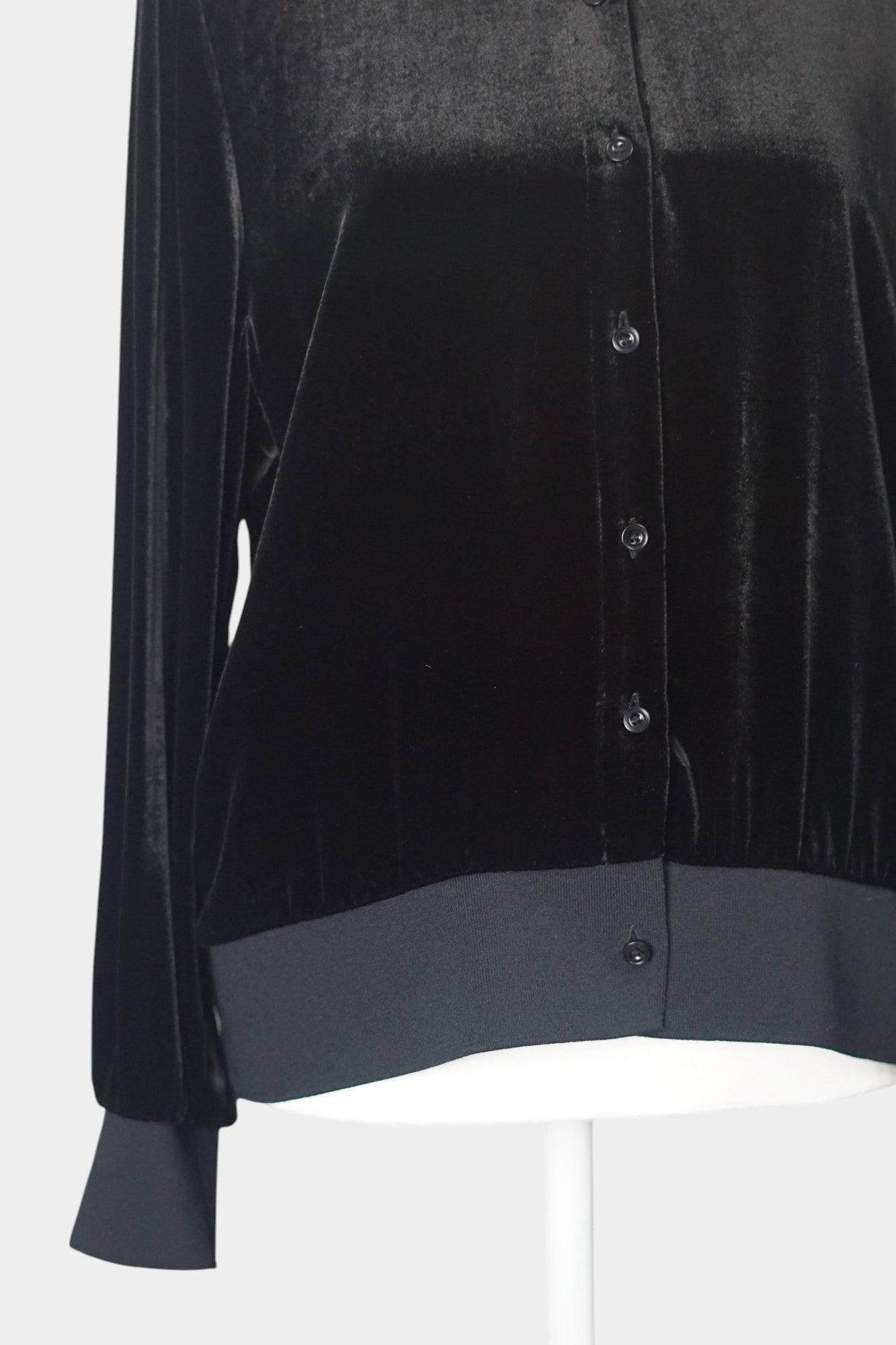 Women's black silk velvet jacket featuring a button-down front, ribbed stand collar, and ribbed cuffs and hem on a mannequin.