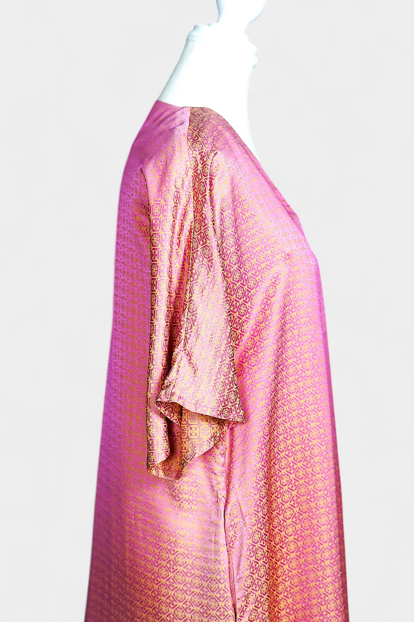 Women's pink and gold Song Brocade dress with a geometric lattice pattern and V-neckline on a mannequin