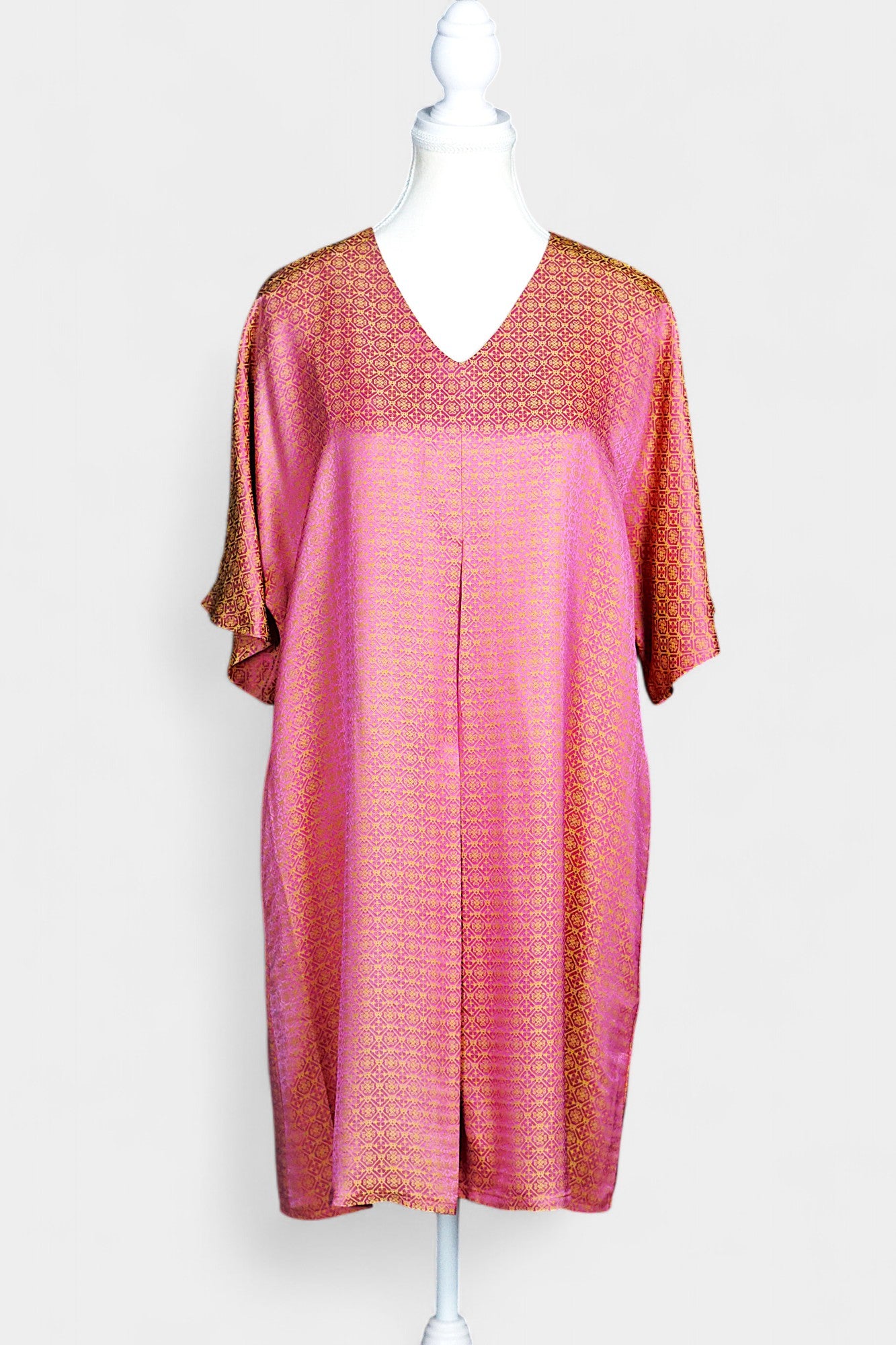 Women's pink and gold Song Brocade dress with a geometric lattice pattern and V-neckline on a mannequin