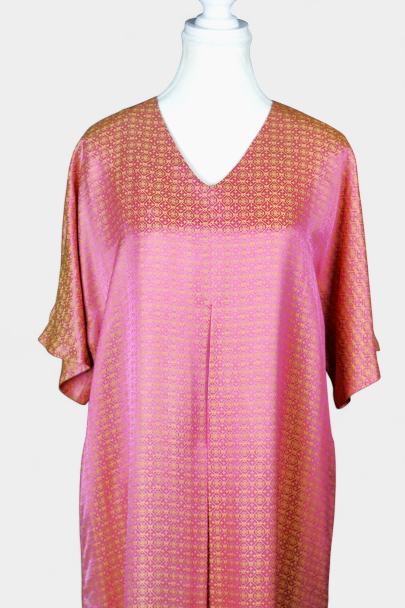 Women's pink and gold Song Brocade dress with a geometric lattice pattern and V-neckline on a mannequin