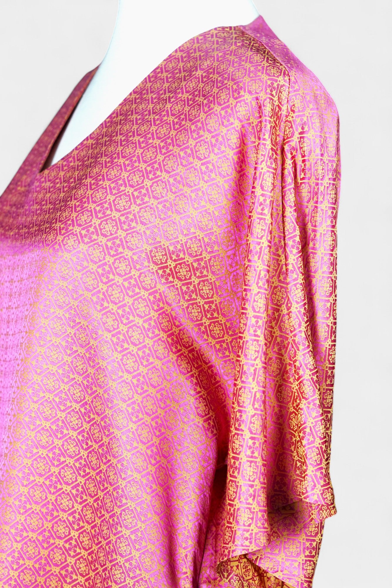 Women's pink and gold Song Brocade dress with a geometric lattice pattern and V-neckline on a mannequin