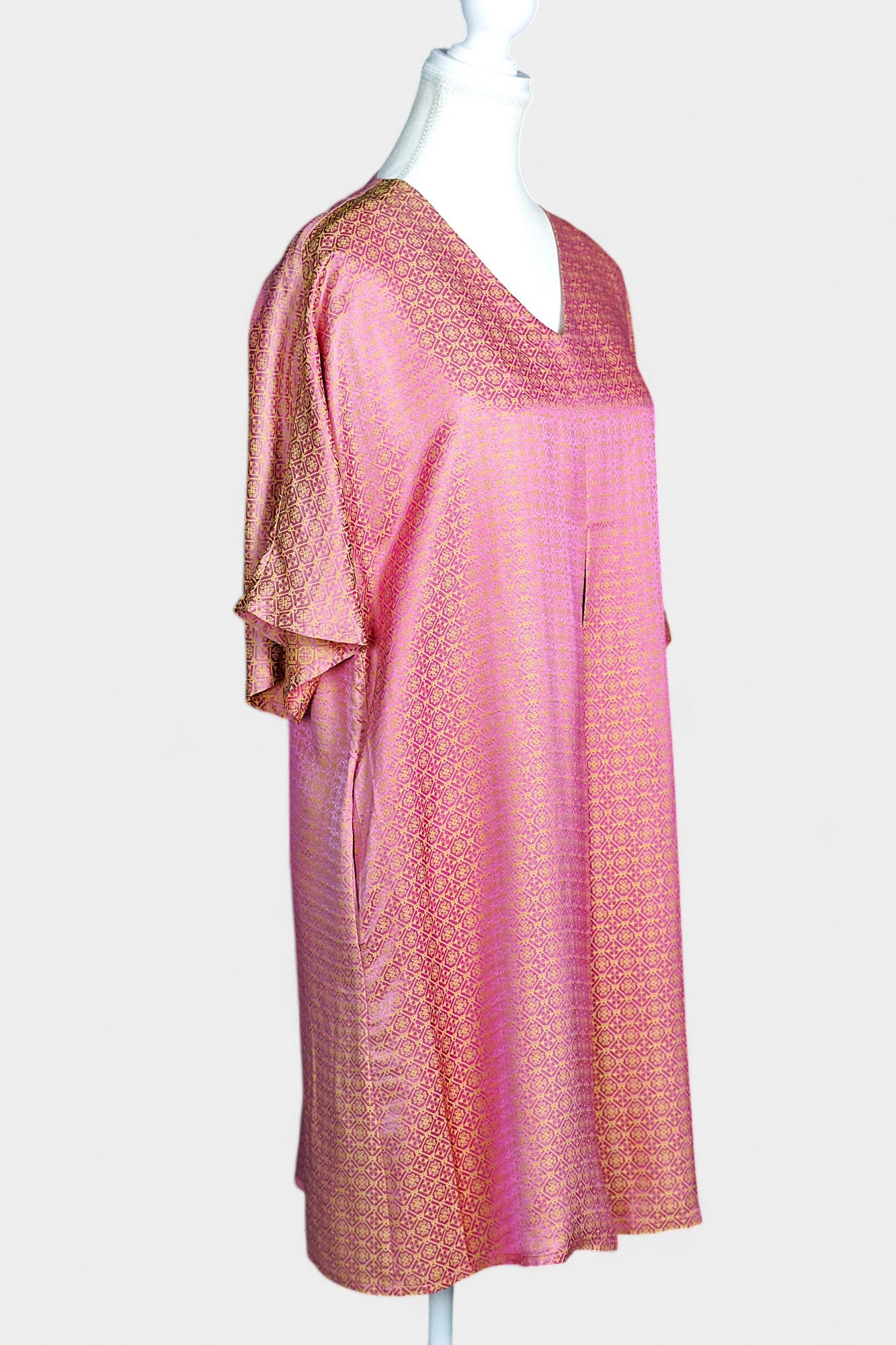 Women's pink and gold Song Brocade dress with a geometric lattice pattern and V-neckline on a mannequin