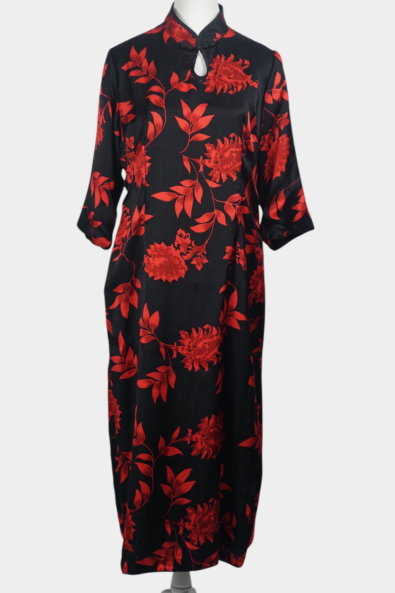 Traditional Chinese style midi dress in lustrous black fabric, adorned with vibrant red floral motifs and a teardrop cutout at the neck