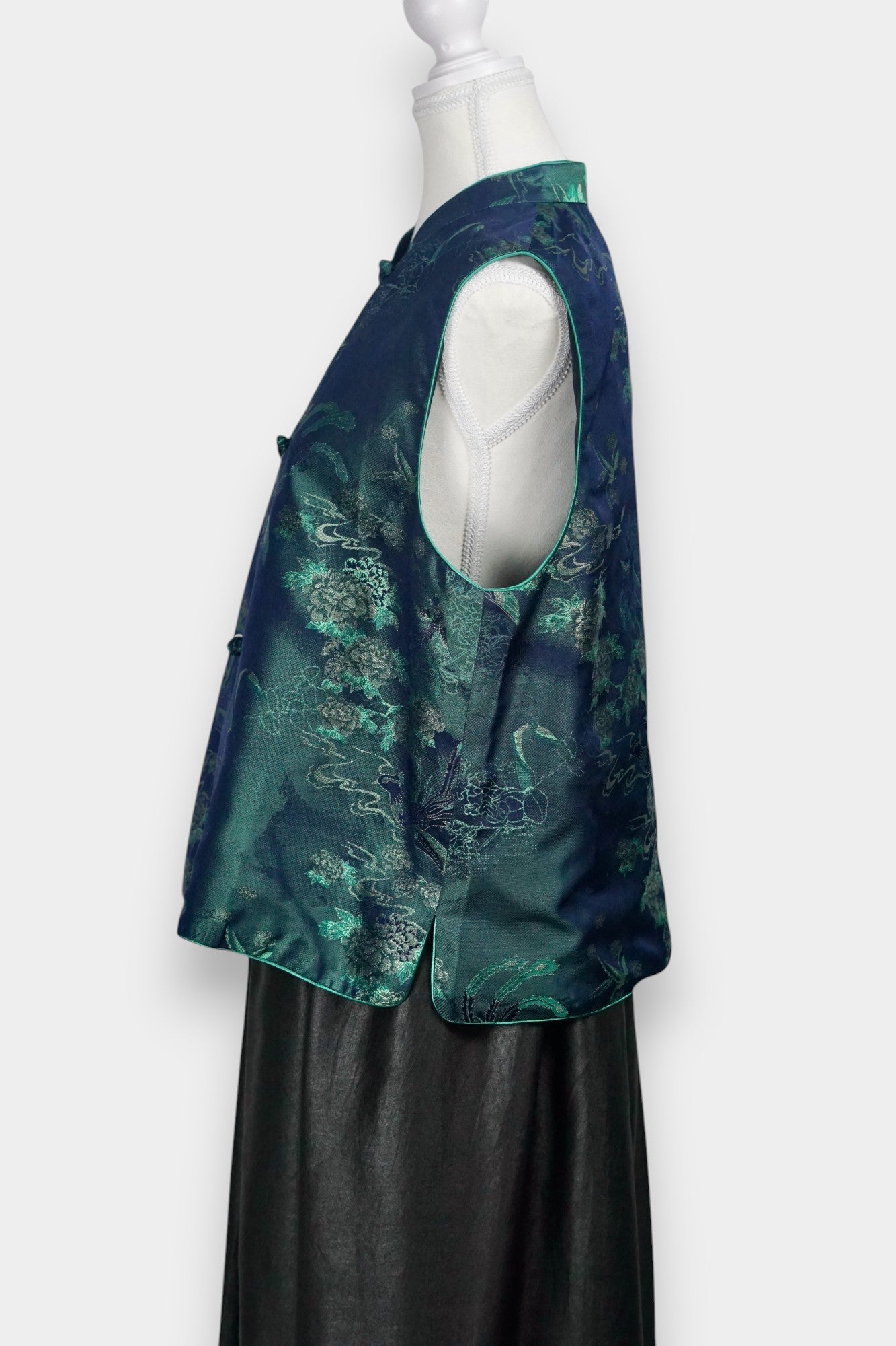 Traditional Chinese Tang suit vest featuring intricate cloud and bird patterns in teal and navy.