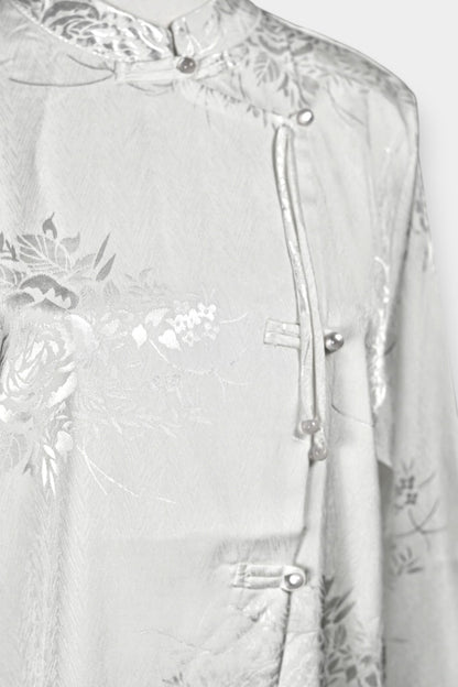 Lustrous ivory Song Jin top adorned with subtle floral patterns and a side-fastening front