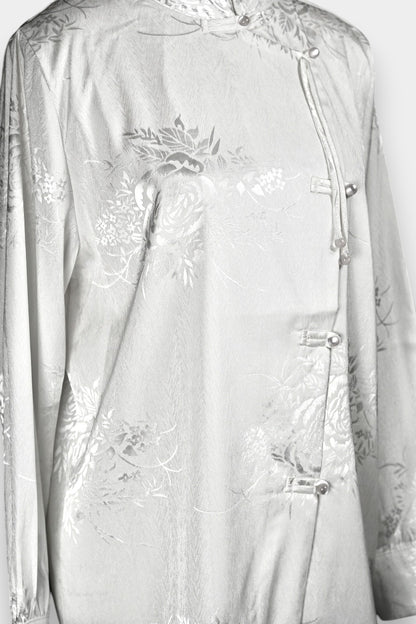 Lustrous ivory Song Jin top adorned with subtle floral patterns and a side-fastening front