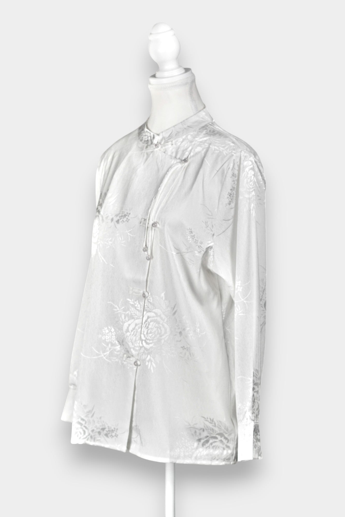 Lustrous ivory Song Jin top adorned with subtle floral patterns and a side-fastening front