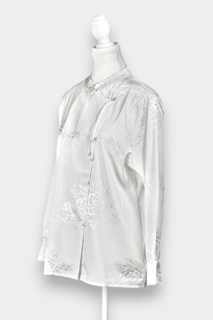 Lustrous ivory Song Jin top adorned with subtle floral patterns and a side-fastening front