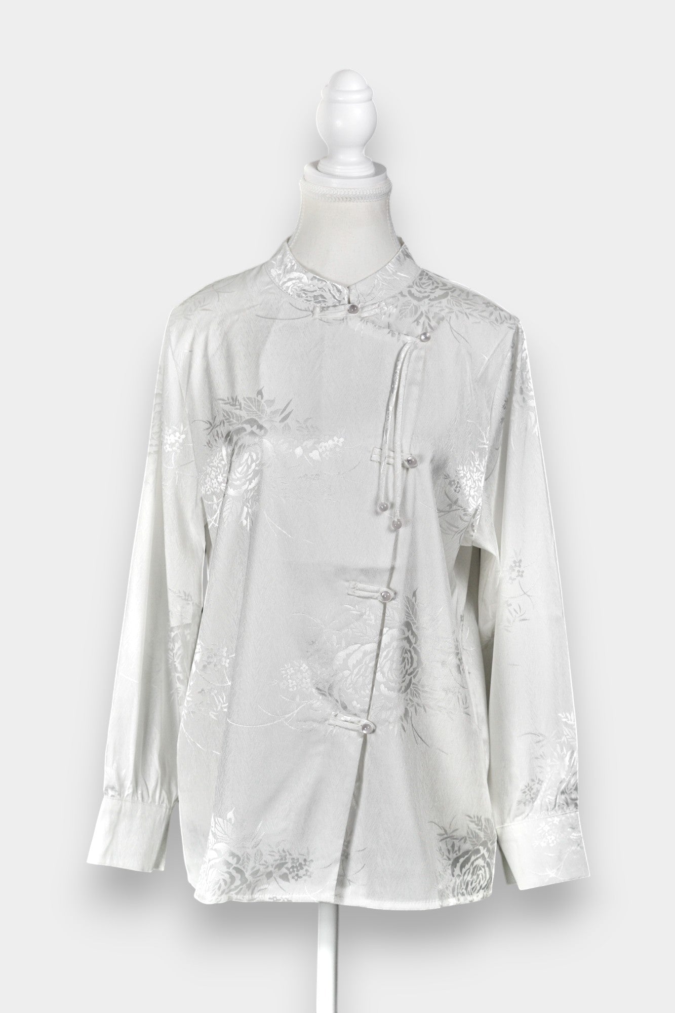 Lustrous ivory Song Jin top adorned with subtle floral patterns and a side-fastening front