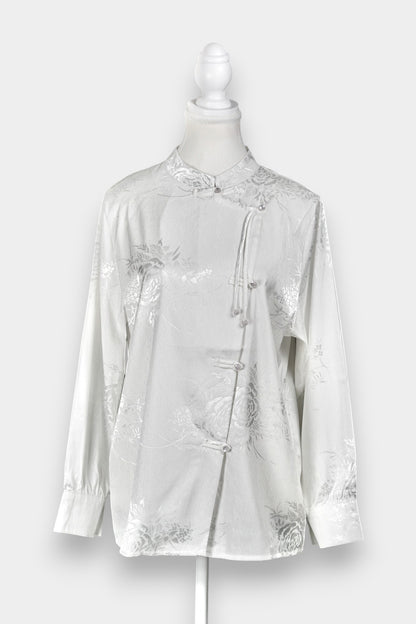 Lustrous ivory Song Jin top adorned with subtle floral patterns and a side-fastening front