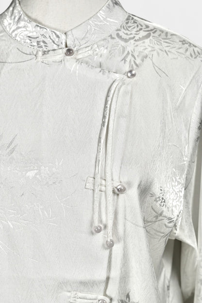 Lustrous ivory Song Jin top adorned with subtle floral patterns and a side-fastening front