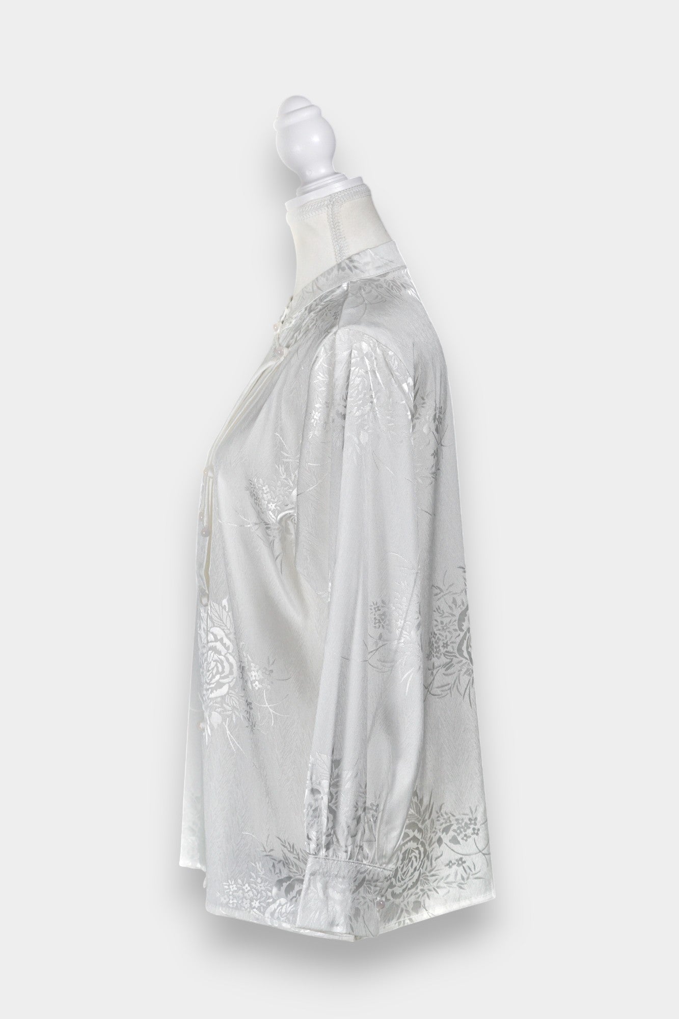 Lustrous ivory Song Jin top adorned with subtle floral patterns and a side-fastening front
