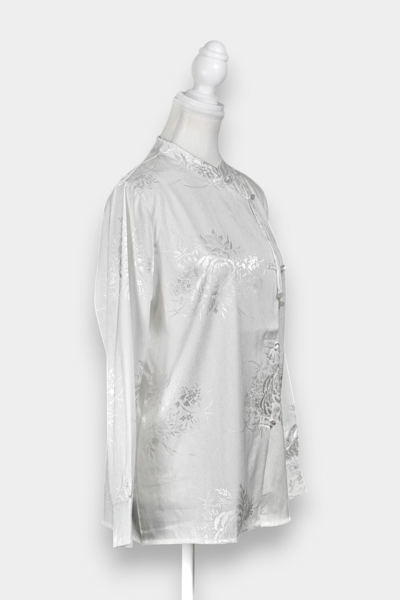 Lustrous ivory Song Jin top adorned with subtle floral patterns and a side-fastening front