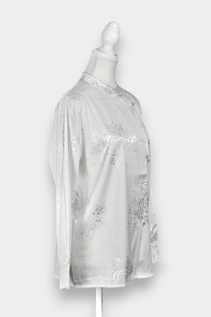 Lustrous ivory Song Jin top adorned with subtle floral patterns and a side-fastening front