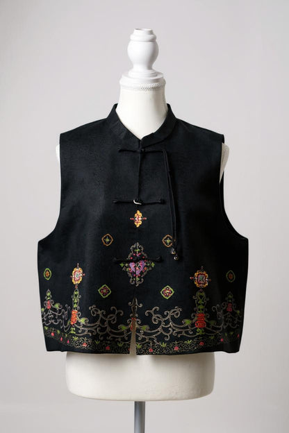 Women's black Song Brocade vest with a mandarin collar, frog buttons, and colorful woven traditional patterns on the hem.