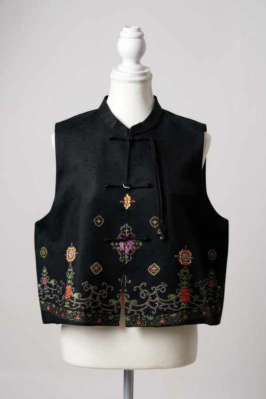 Women's black Song Brocade vest with a mandarin collar, frog buttons, and colorful woven traditional patterns on the hem.