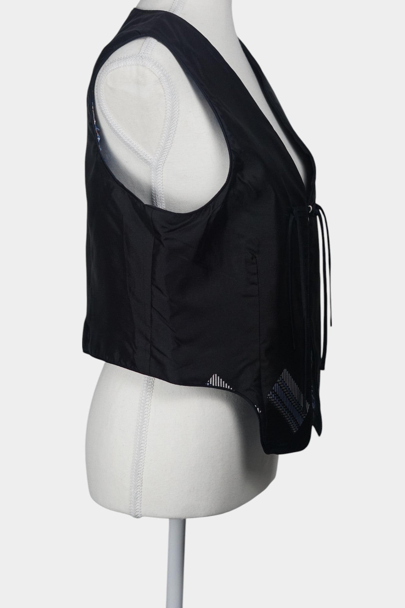 Black Song Brocade vest with V-neck, front tie closure, and white geometric hem details