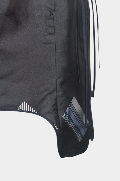 Black Song Brocade vest with V-neck, front tie closure, and white geometric hem details